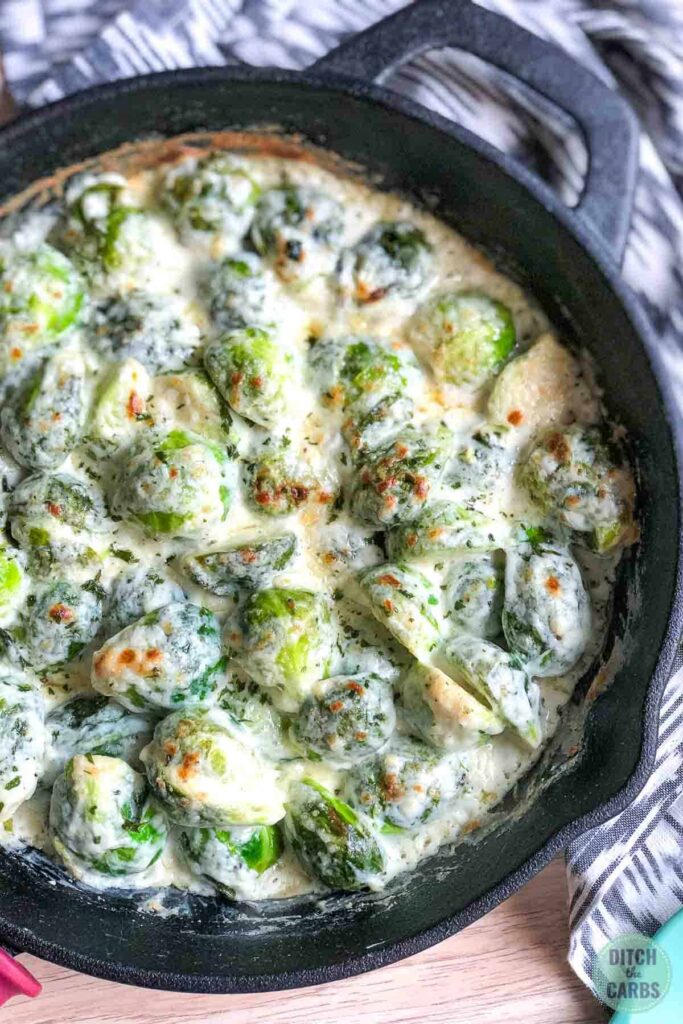 Creamed Brussels sprouts baked in a cast-iron skillet. Cooling on the counter.