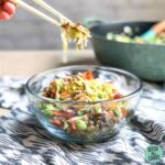 crack slaw in a glass bowl being lifted by chopsticks