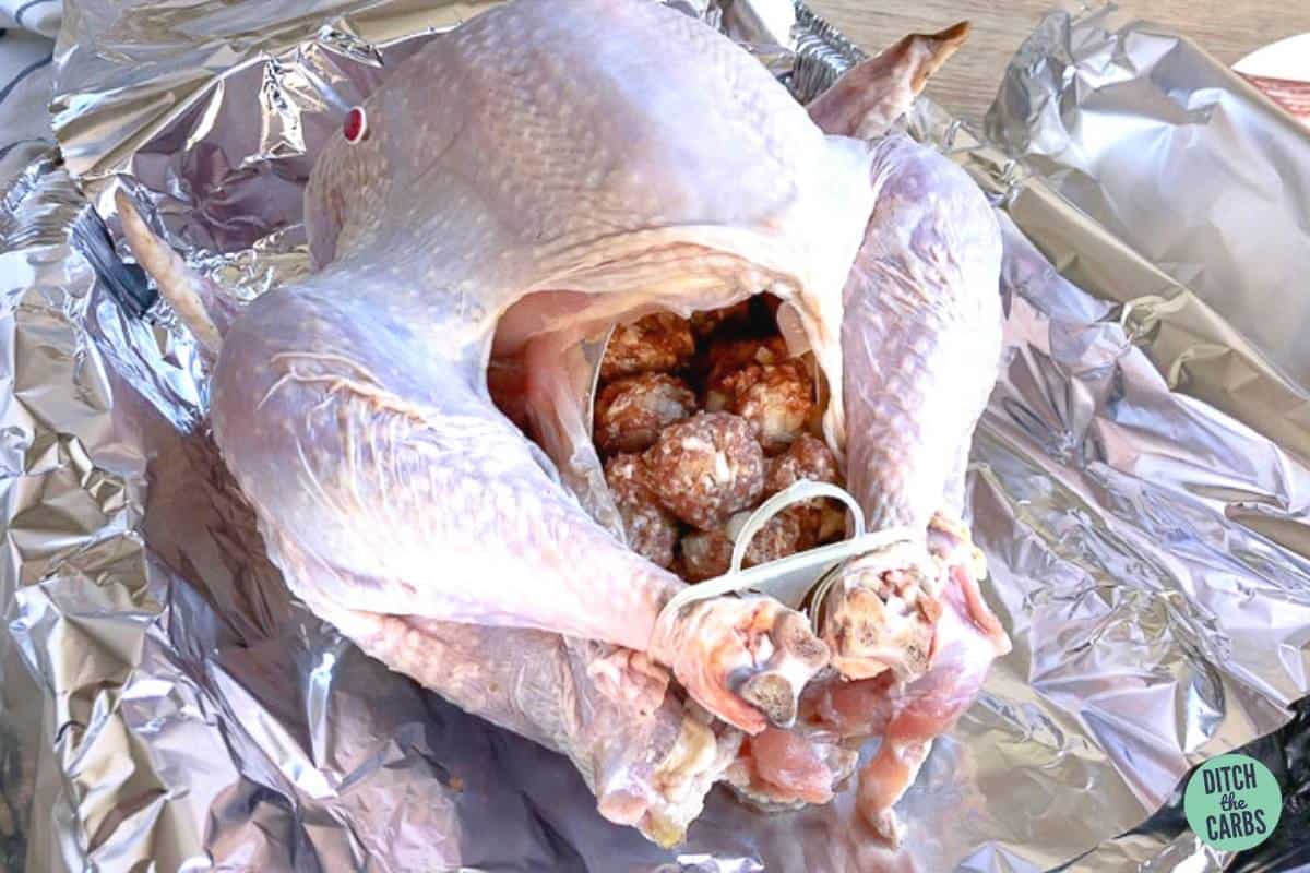 a turkey being filled with pork keto stuffing