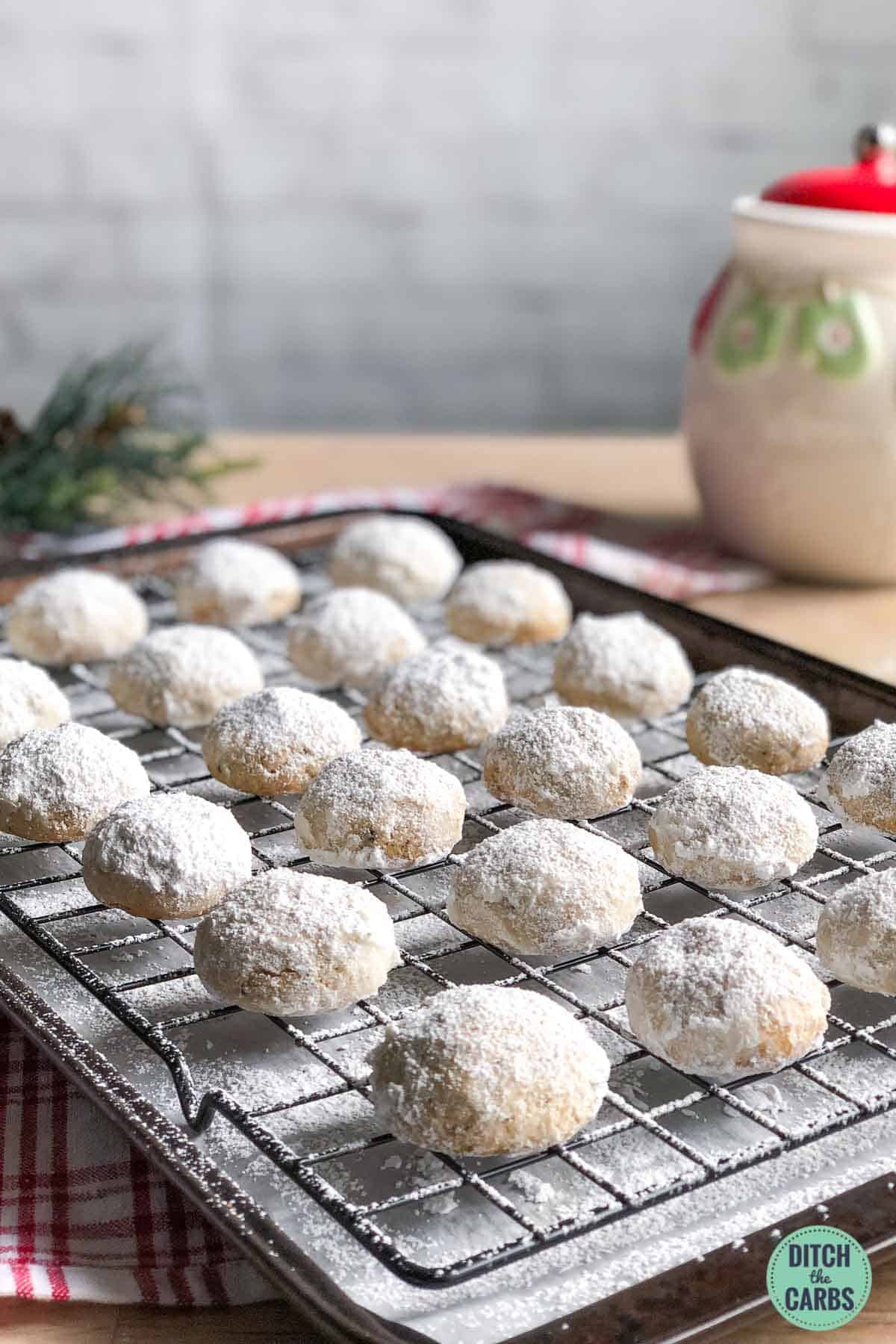 low carb cookies coated in powdered sugar on a cooling rack