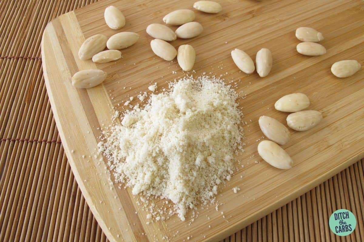 blanched almonds on a wooden board with homemade almond flour