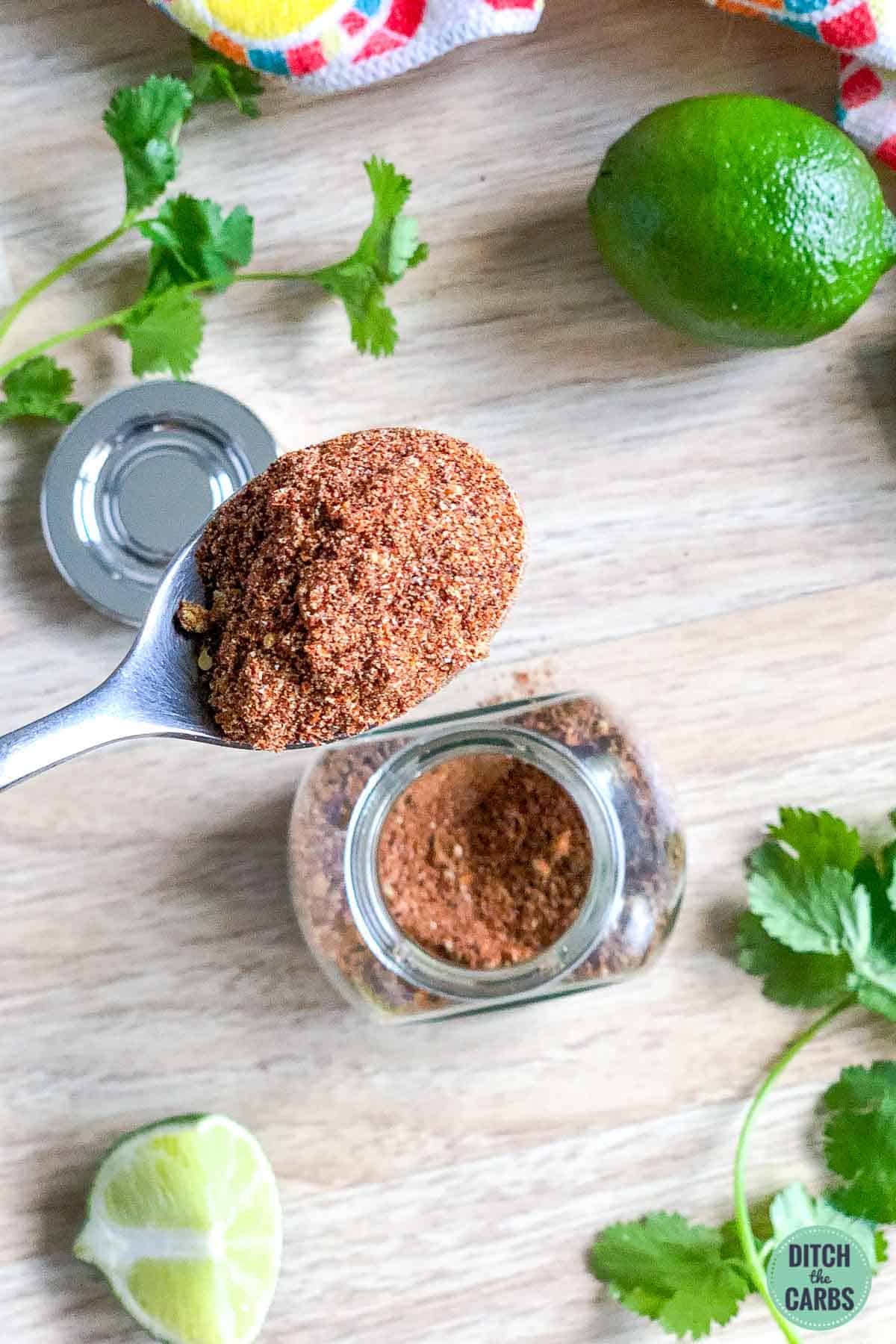 Spoonful of keto taco seasoning with lime in the background