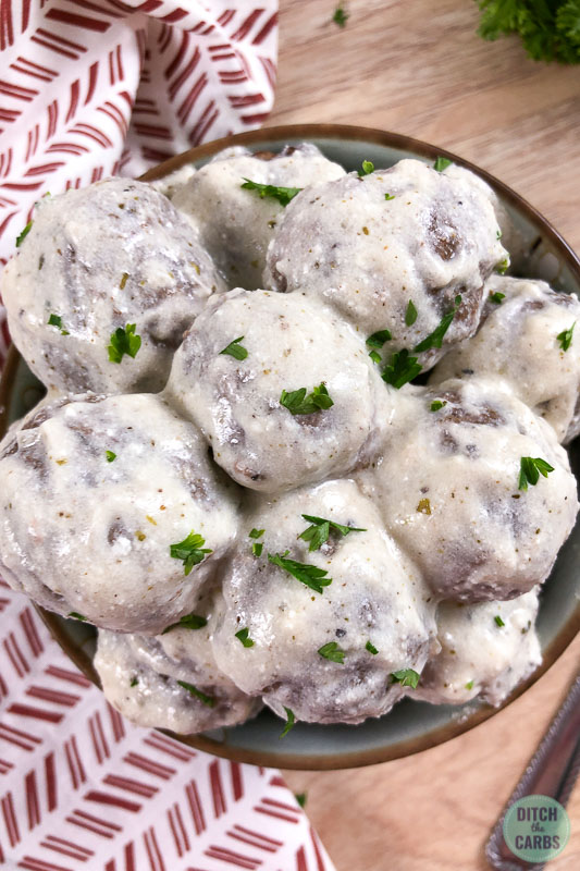 bowl of creamy meatballs with fresh herbs
