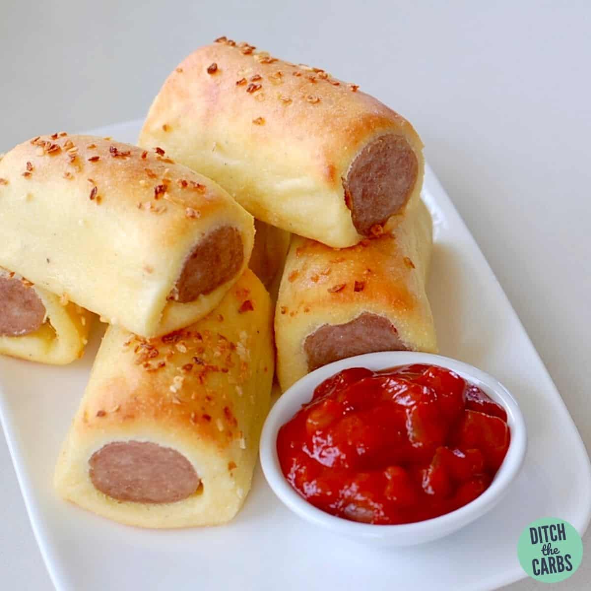 keto sausage rolls on a white plate with ketchup