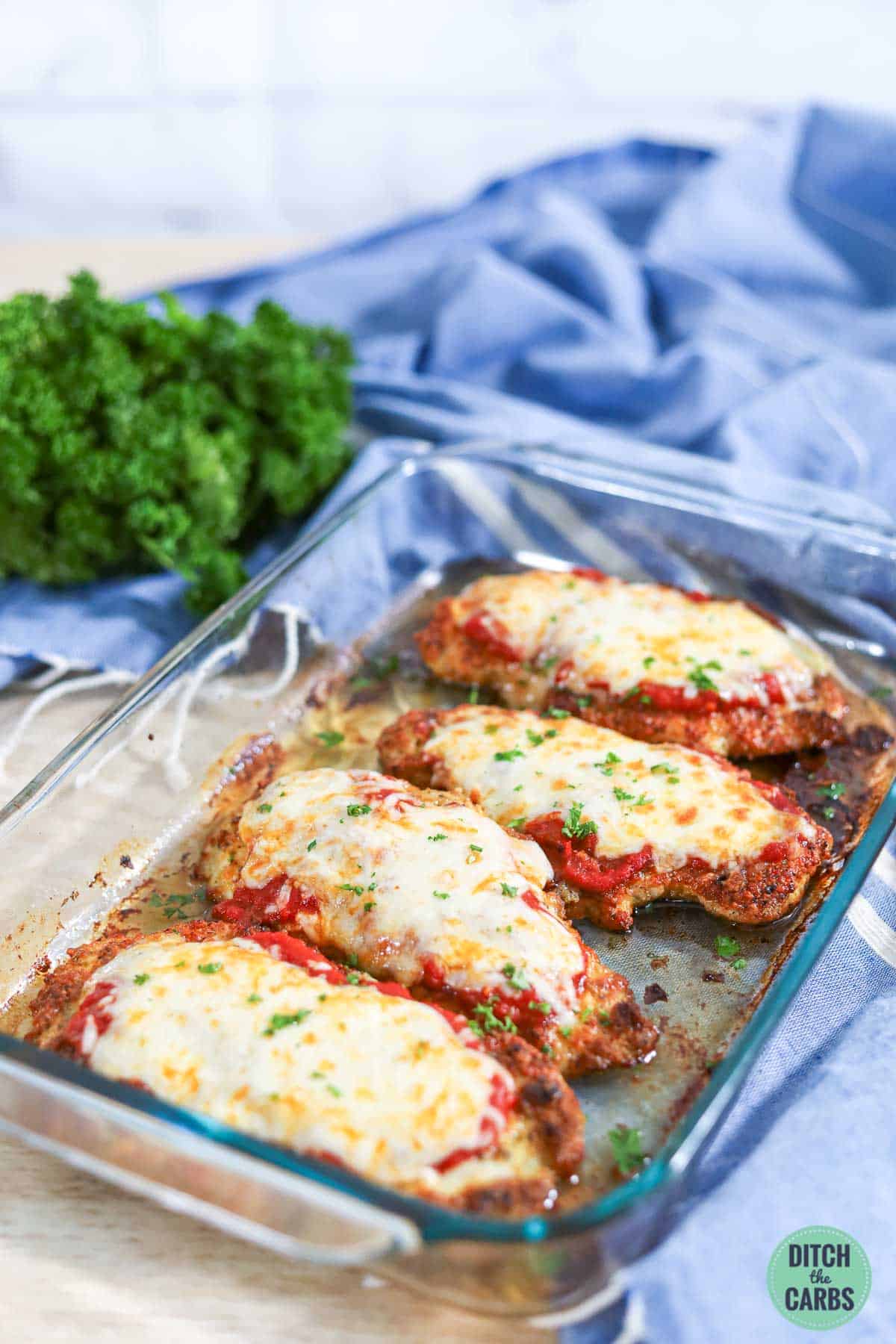 Baking dish filled with 4 servings of keto chicken parm topped with marina and melted cheese
