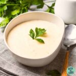 Low Carb Creamed Chicken Soup in a white bowl with fresh herbs