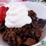 A close up of a slow cooker chocolate lava cake served with whipped cream