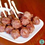 A plate of meatballs with bamboo skewers