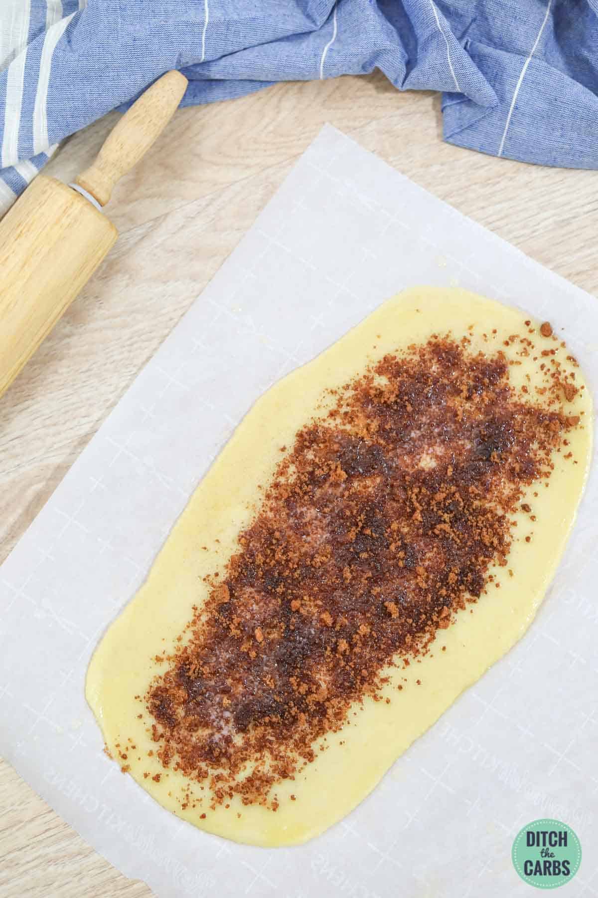 Keto dough rolled out with cinnamon sprinkled on top