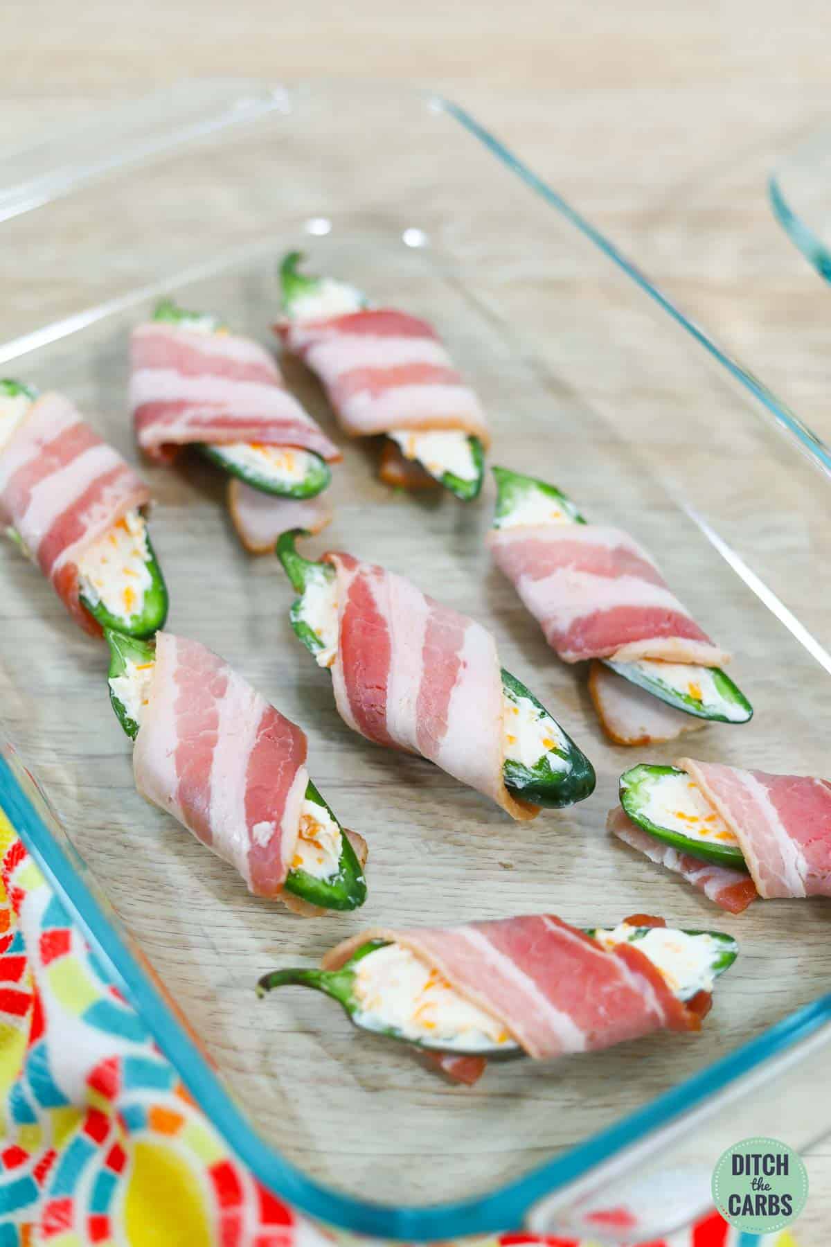 jalapeno peppers wrapped with bacon before baking
