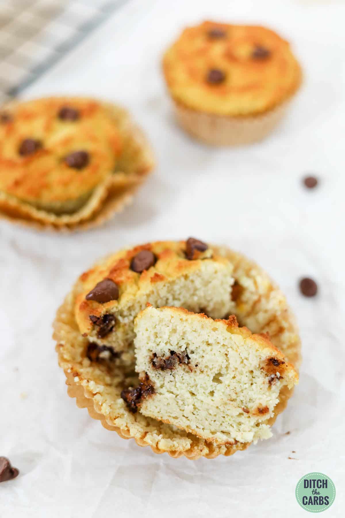 keto chocolate chip muffins in liners;  one is cut in half