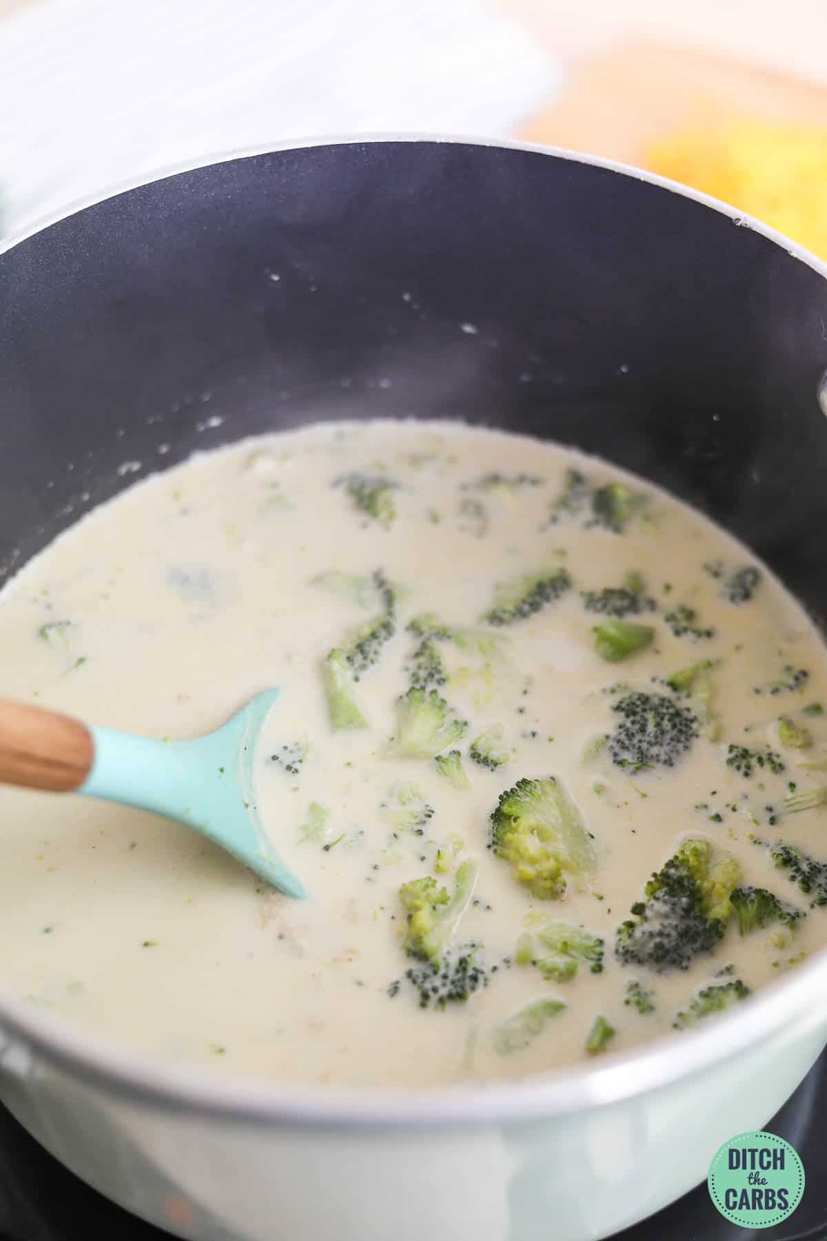 mixing broccoli, cream and broth into stock pot