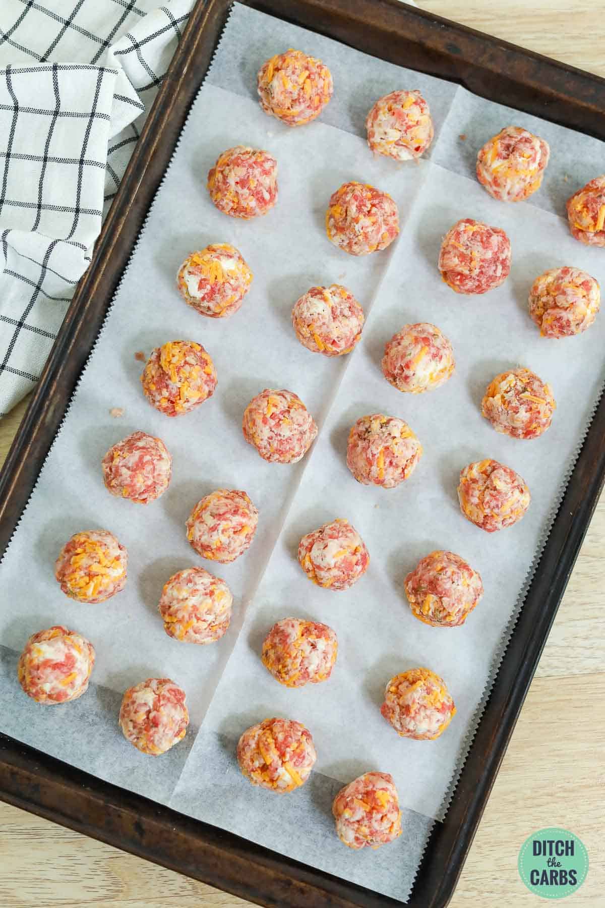 low carb sausage balls on a lined baking sheet