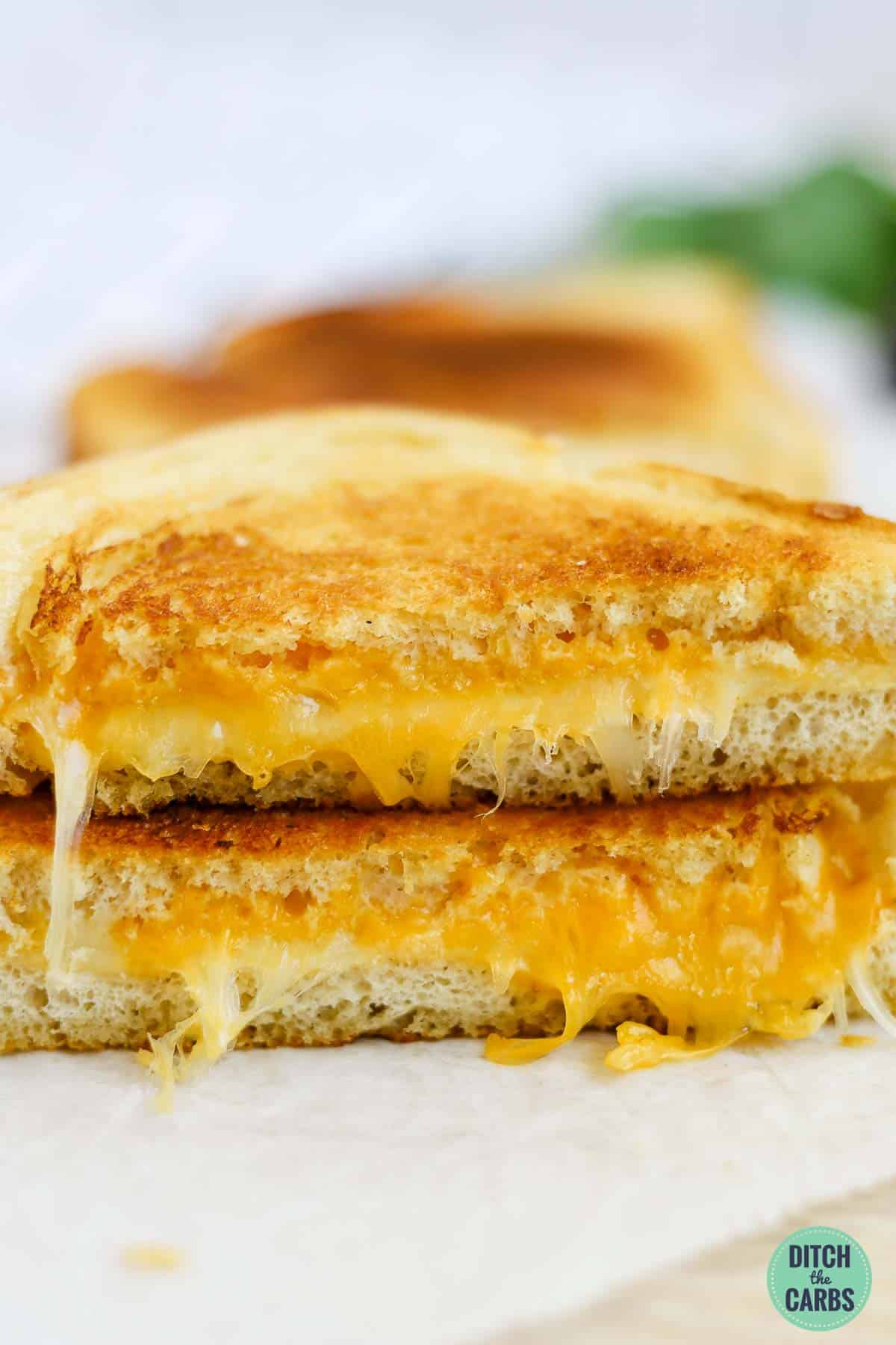 A keto grilled cheese sandwich cut in half and stacked on top of each other.