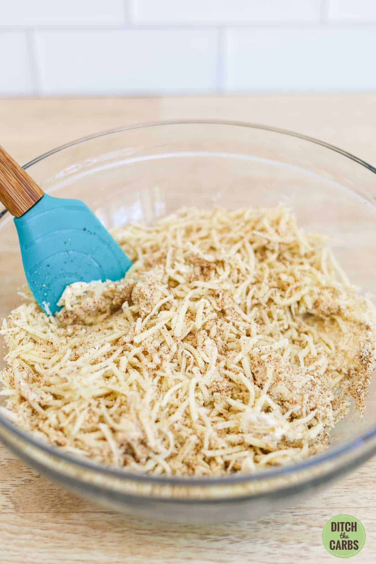 Shredded cheese, almond flour, ground flaxseed, and yogurt mixed together in a microwave safe bowl. It is ready to melt.